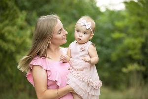 glücklich Mama hält ein süß Tochter im ihr Waffen. foto