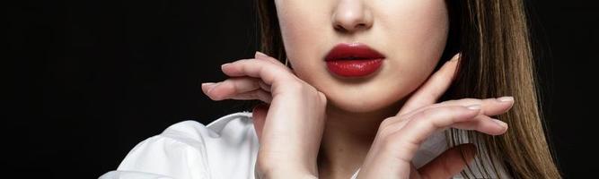 rot sexy Lippen schließen hoch. Hälfte Gesicht von Modell- Mädchen isoliert auf schwarz Hintergrund. foto