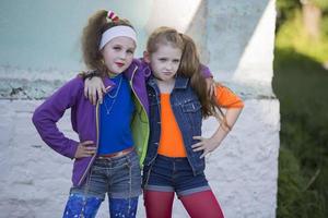 zwei sind komisch wenig Mädchen mit hell bilden gekleidet im das Stil von das neunziger Jahre. foto