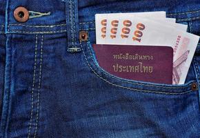 Thailand Reisepass und Geld im Jeans Tasche foto