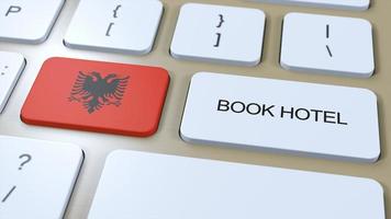 Buch Hotel im Albanien mit Webseite online. Taste auf Computer Klaviatur. Reise Konzept 3d Animation. Buch Hotel Text und National Flagge. 3d Illustration foto