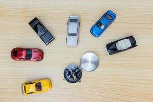 Konzept zum reisen. Spielzeug Autos und Kompass isoliert auf hölzern Hintergrund. nach etwas bearbeitet. foto