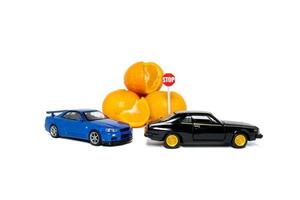 ein Foto nach etwas bearbeitet, 2 Spielzeug Autos Versuchen zu erreichen Orangen Frucht. ein Konzept von nicht zu Essen auch viel sogar wenn es ist ein gesund Frucht.