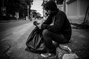 asiatischer mann ist obdachlos an der seitenstraße, ein fremder muss alleine auf der straße leben, weil er keine familie hat. foto