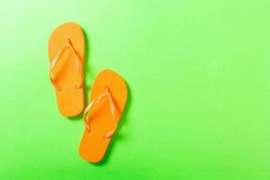 Orange Flip Flops auf Grün Hintergrund. oben Aussicht mit Kopieren Raum foto