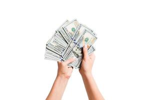 oben Aussicht von ein bündeln von Geld im weiblich Hände. Bild von Zählen Dollar auf Weiß isoliert Hintergrund. MwSt Konzept foto