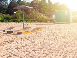 Strand mit Sonnenliegen foto