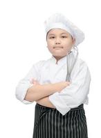 Kind Koch halt Schneebesen mit Koch Hut und Schürze foto