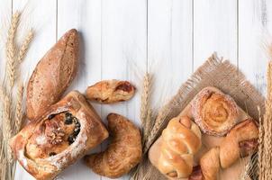 Sortiment von gebacken Brot und Weizen auf Weiß Holz Tabelle foto