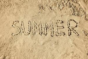 Sommer- Wort handgeschrieben auf Sand foto