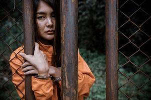 Gefangener im orangefarbenen Robenkonzept, Porträt einer asiatischen Frau in Gefängnisuniformen auf weißem Hintergrund, foto