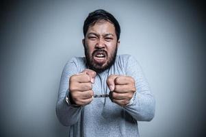 asiatisch gut aussehend Mann wütend auf Weiß Hintergrund, Porträt von jung Stress männlich Konzept, schlecht Stimmung nach reden auf das Telefon foto