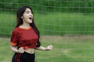 junge schöne asiatische frau trägt fußballspieler jubeln sport, weibliche fans fußball jubelspiel foto