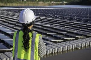 asiatisch Ingenieur Arbeiten beim schwebend Solar- Bauernhof, erneuerbar Energie, Techniker und Investor Solar- Paneele Überprüfung das Paneele beim Solar- Energie Installation foto