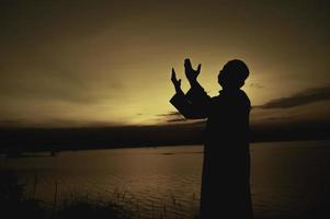 Silhouette jung asiatisch Muslim Mann beten auf Sonnenuntergang, Ramadan Festival Konzept foto