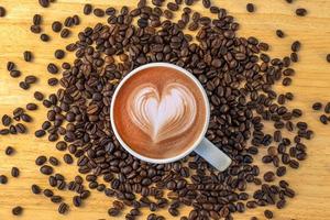 Draufsicht einer Tasse Kaffee mit Bohnen auf hölzernem Hintergrund. foto