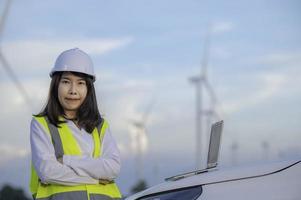 Ingenieurinnen arbeiten und halten den Bericht an der Windturbinenpark-Kraftwerksstation auf dem Berg, Thailand-Leute foto