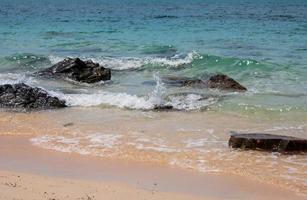 landschaft sommer vorderansicht tropisch meer strand felsen blau weiß sand hintergrund ruhig natur ozean schön welle absturz spritzwasser reise nang ram strand ostthailand chonburi exotisch horizont. foto