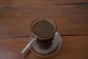 schließen oben Foto ein Tasse von Arabica Kaffee mit Löffel von hoch Winkel. das Foto ist geeignet zu verwenden zum Kaffee Geschäft Hintergrund, Speisekarte Poster und Kaffee Inhalt Medien.