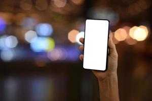 Hand halten Smartphone mit leer Bildschirm auf Bokeh Licht Hintergrund foto