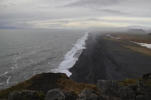 Aussicht zu endlos Ozean schwarz vulkanisch Sand Strand von dyrholaey Kap Standpunkt, Vik, Süd Island foto