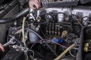 Auto Motor Reparatur. Diesel Motor Dienstleistungen. Hände mit ein Mechaniker mit ein Schlüssel Reparatur Mercedes Teile. foto