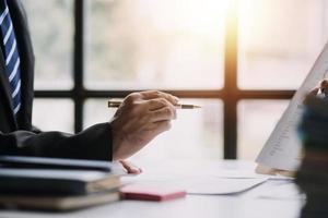 finanzanalysten analysieren während einer diskussion auf einem unternehmenstreffen geschäftsfinanzberichte zu einem investitionsprojekt zur planung digitaler tabletten und zeigen die ergebnisse ihrer erfolgreichen teamarbeit. foto