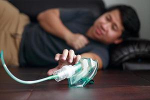 krank asiatisch jung Mann mit Vernebler zum Asthma und Atemwege Krankheiten beim heim. foto