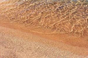 sandig Strand mit Kieselstein und Meer mit Wellen und Welle Hintergrund. sonnig Tag. reisen, Sommer- im heiß Länder. Kopieren Raum foto