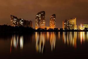 Nachtstadt mit Reflexion von Häusern im Fluss foto