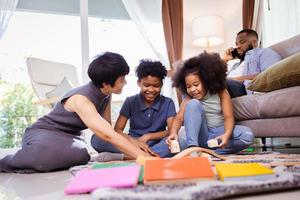glücklich schwarz Familie mit Kinder spielen beim heim, Ideal zum Erziehung und Lebensstil Inhalt foto