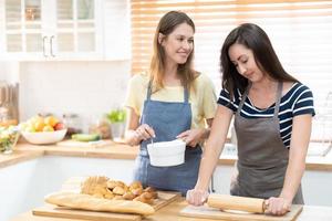 zwei kaukasisch Frauen Kochen Pizza zusammen im das Küche. das Konzept von Zuhause gekocht Essen und lgbt Beziehungen. Familie und Vielfalt Konzept. lgbt Liebe. foto