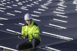 asiatisch Ingenieur Arbeiten beim schwebend Solar- Leistung Pflanze, erneuerbar Energie, Techniker und Investor Solar- Paneele Überprüfung das Paneele beim Solar- Energie Installation foto