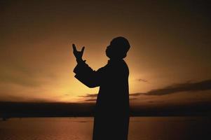 Silhouette jung asiatisch Muslim Mann beten auf Sonnenuntergang, Ramadan Festival Konzept foto