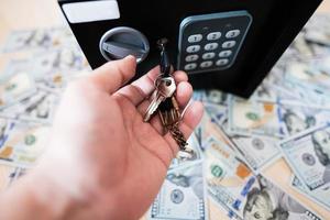 männlich öffnen mit Schlüssel sperren sicher Tür gegen Dollar Geld. foto