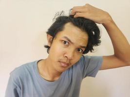 schockiert Gesicht von asiatisch Mann bekommen kahl und hat verloren Haar im isoliert Weiß Hintergrund foto