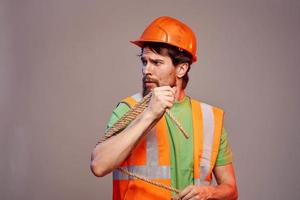 männlich Baumeister Orange schwer Hut Arbeit Fachmann grau Hintergrund foto