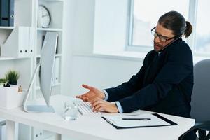 Büro Arbeiter im das Büro Gesten mit seine Hände Computer foto