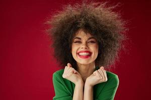 positiv jung Frau mit lockig Haar Grimasse posieren Emotion Farbe Hintergrund unverändert foto