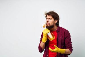 Reiniger mit Waschmittel im Gummi Handschuhe Hände Fachmann Bedienung Rendern abgeschnitten Aussicht von Hausaufgaben foto