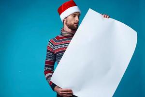 gut aussehend Mann im ein Santa Hut halten ein Banner Urlaub isoliert Hintergrund foto