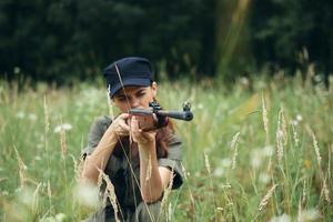 Frau auf draussen im das Schutz mit Waffen im Hand, das Sicht von frisch Luft Waffen Grün foto