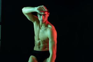 sportlich Mann mit gepumpt Muskeln auf seine Bauch posieren auf isoliert Hintergrund abgeschnitten Aussicht foto