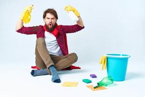 ein Mann im ein rot Regenjacke Sitzung beim Zuhause Waschen das Böden Bereitstellung Dienstleistungen Arbeit foto