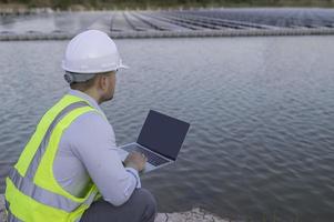 asiatisch Ingenieur Arbeiten beim schwebend Solar- Bauernhof, erneuerbar Energie, Techniker und Investor Solar- Paneele Überprüfung das Paneele beim Solar- Energie Installation foto