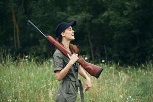 Frau Soldat Waffen auf das Schulter ist ein Spaß Jagd Lebensstil Grün Overall foto