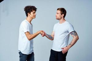 zwei heiter freunde im Weiß T-Shirts Emotionen Studio foto