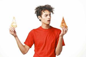 lockiges Haar Kerl schnell Essen im das Hände von ein Snack Essen Diät Licht Hintergrund foto