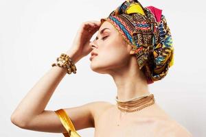 heiter Frau mit mehrfarbig Turban auf ihr Kopf Dekoration posieren foto