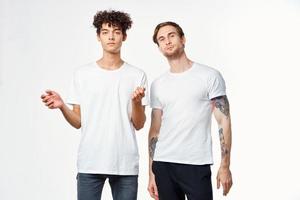 zwei komisch freunde im Weiß T-Shirts Lachen positiv Emotionen foto